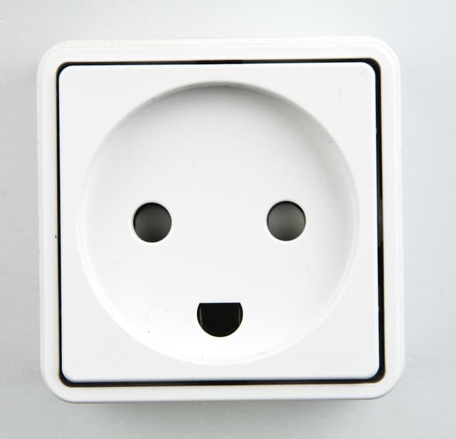 Front view of a Danish power plug. The socket arrangement mimics a face.